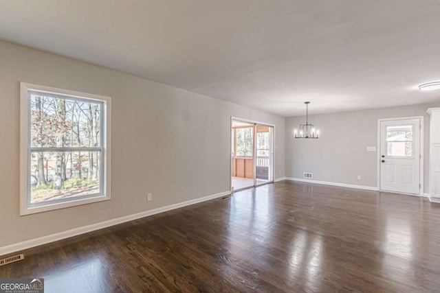 interior space featuring dark hardwood / wood-style flooring and a chandelier