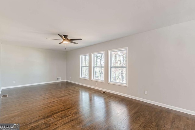 spare room with dark wood-type flooring and ceiling fan