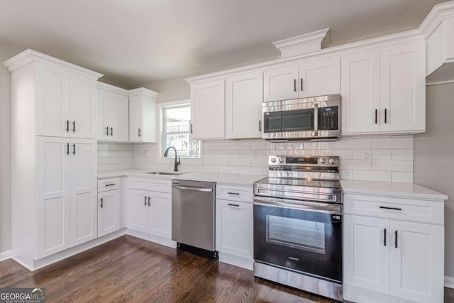 kitchen with tasteful backsplash, sink, white cabinets, stainless steel appliances, and dark wood-type flooring