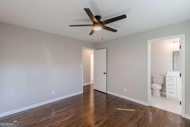 unfurnished bedroom with hardwood / wood-style flooring, ceiling fan, and connected bathroom