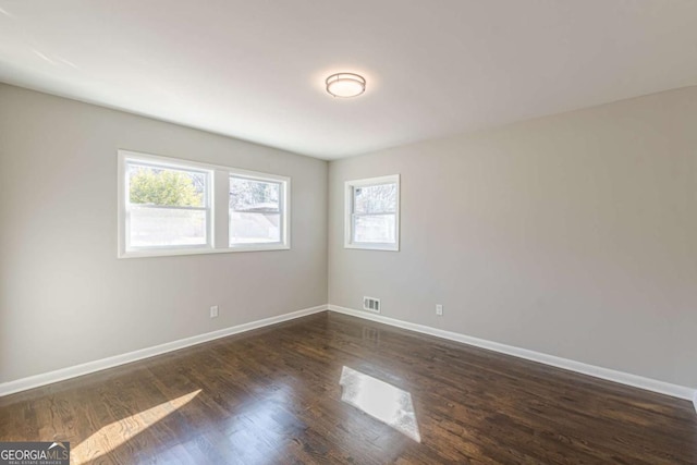 spare room with dark wood-type flooring