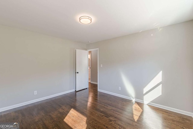 spare room featuring dark wood-type flooring