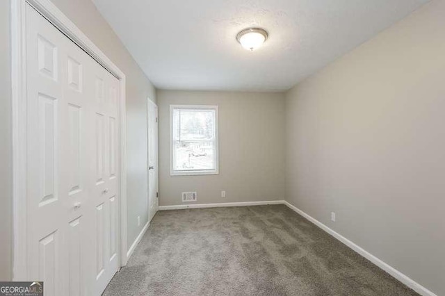 unfurnished bedroom featuring carpet floors and a closet