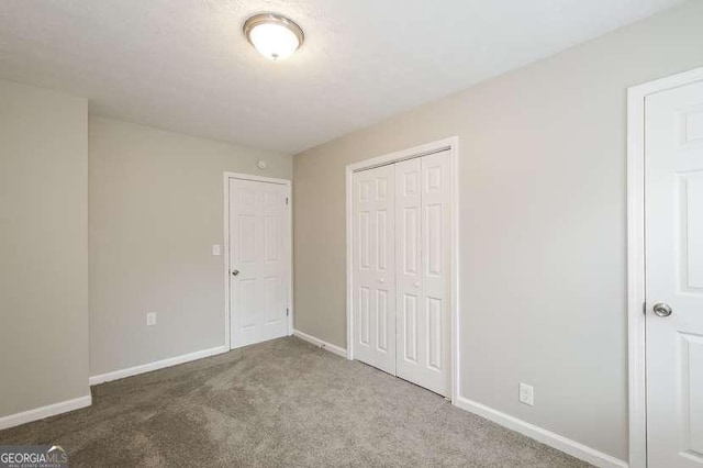 unfurnished bedroom featuring carpet flooring and a closet