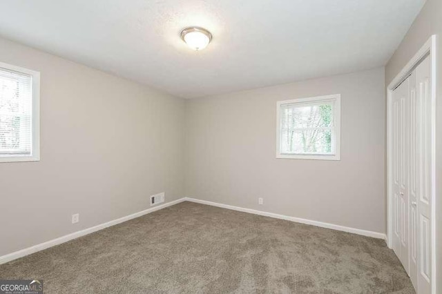 unfurnished bedroom featuring carpet flooring and a closet