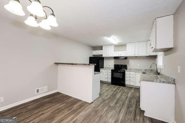 kitchen with pendant lighting, sink, extractor fan, black appliances, and white cabinets