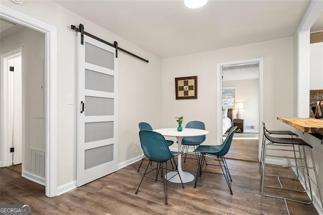 dining room featuring hardwood / wood-style flooring and a barn door