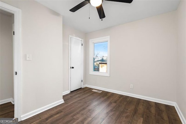 unfurnished room featuring ceiling fan and dark hardwood / wood-style flooring