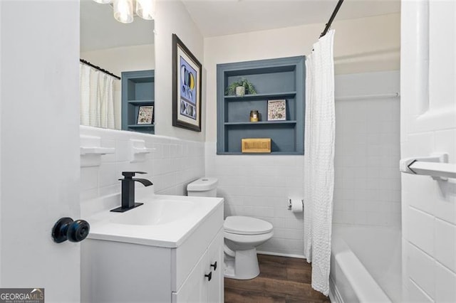 full bathroom featuring shower / tub combo with curtain, tile walls, hardwood / wood-style flooring, vanity, and toilet