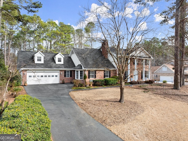 view of front of home featuring an attached garage, aphalt driveway, and brick siding