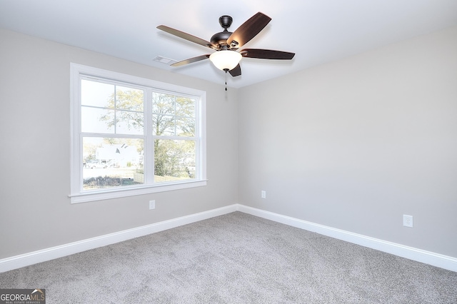 carpeted spare room featuring ceiling fan