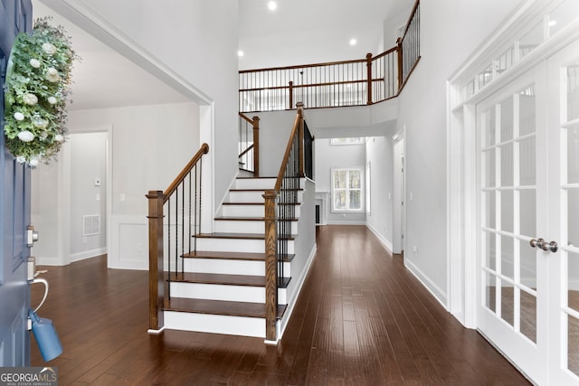 entrance foyer with a high ceiling, dark wood-type flooring, and french doors