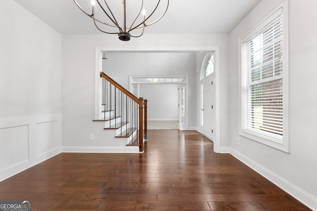 foyer with dark hardwood / wood-style flooring and a notable chandelier