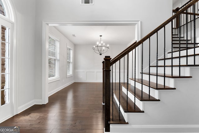 entrance foyer with dark hardwood / wood-style flooring and a chandelier