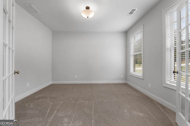 carpeted empty room featuring french doors