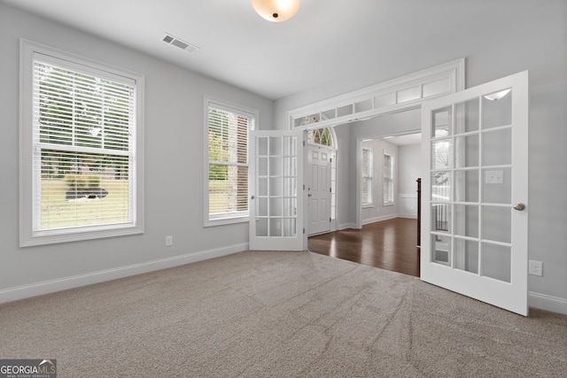 unfurnished room with dark carpet and french doors