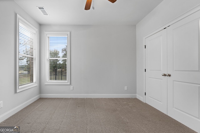 unfurnished bedroom with ceiling fan, a closet, and light carpet