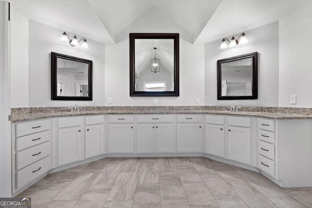 bathroom featuring lofted ceiling and vanity