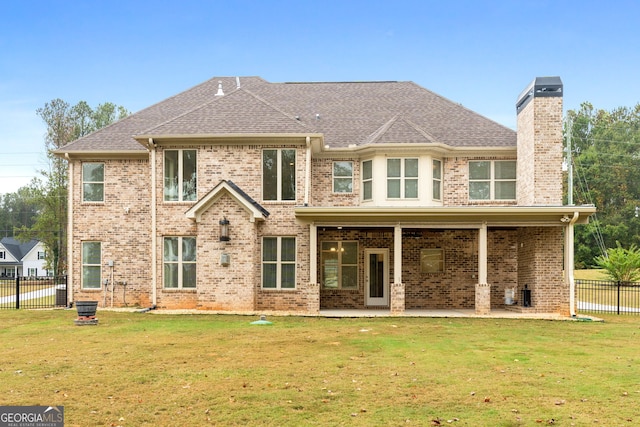 back of house with a lawn and a patio