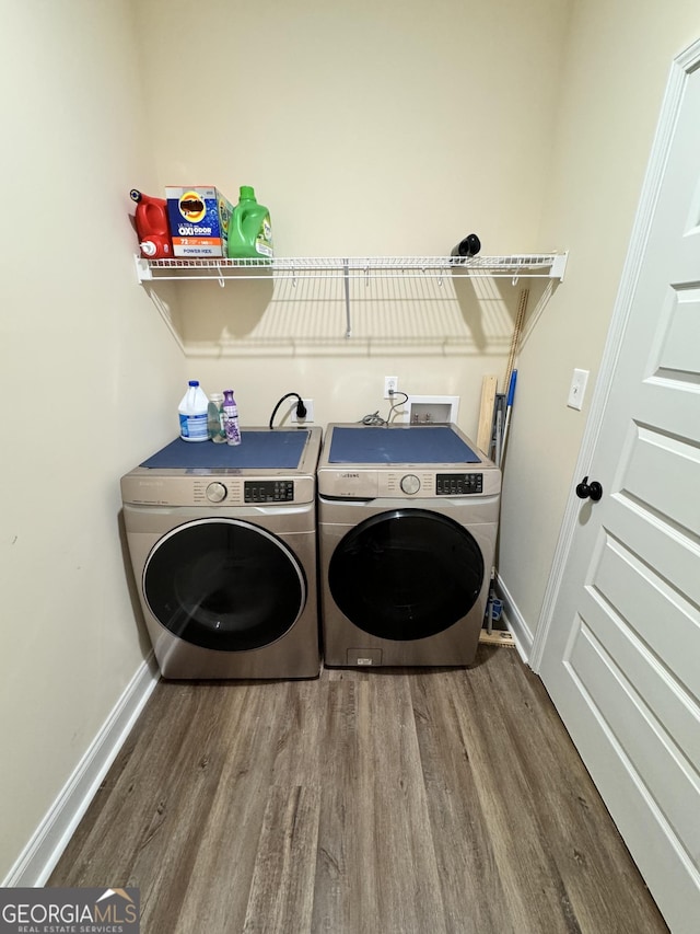 laundry area with hardwood / wood-style flooring and washing machine and clothes dryer