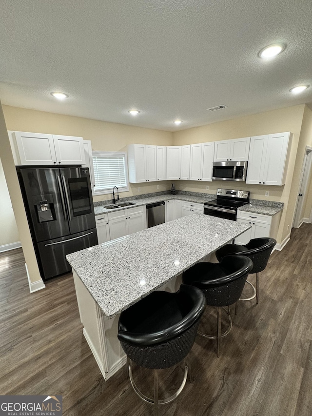 kitchen featuring stainless steel appliances, a center island, and a breakfast bar