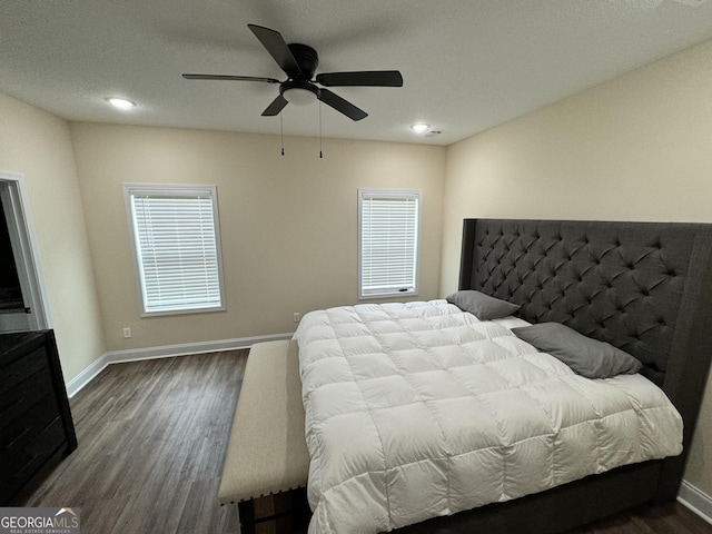 bedroom featuring multiple windows, hardwood / wood-style floors, and ceiling fan