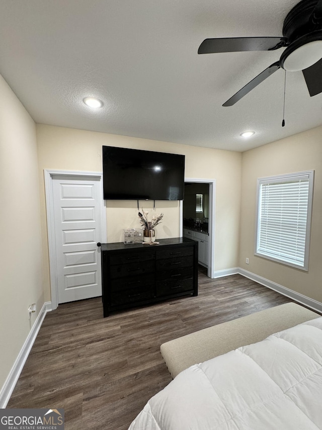 bedroom featuring ceiling fan, dark hardwood / wood-style floors, and a textured ceiling