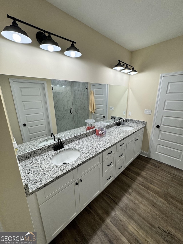 bathroom featuring wood-type flooring, vanity, and walk in shower