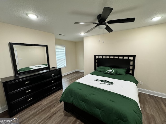 bedroom with ceiling fan, wood-type flooring, and a textured ceiling