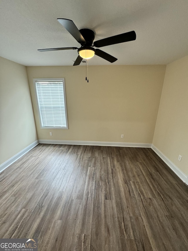 unfurnished room with dark wood-type flooring and a textured ceiling