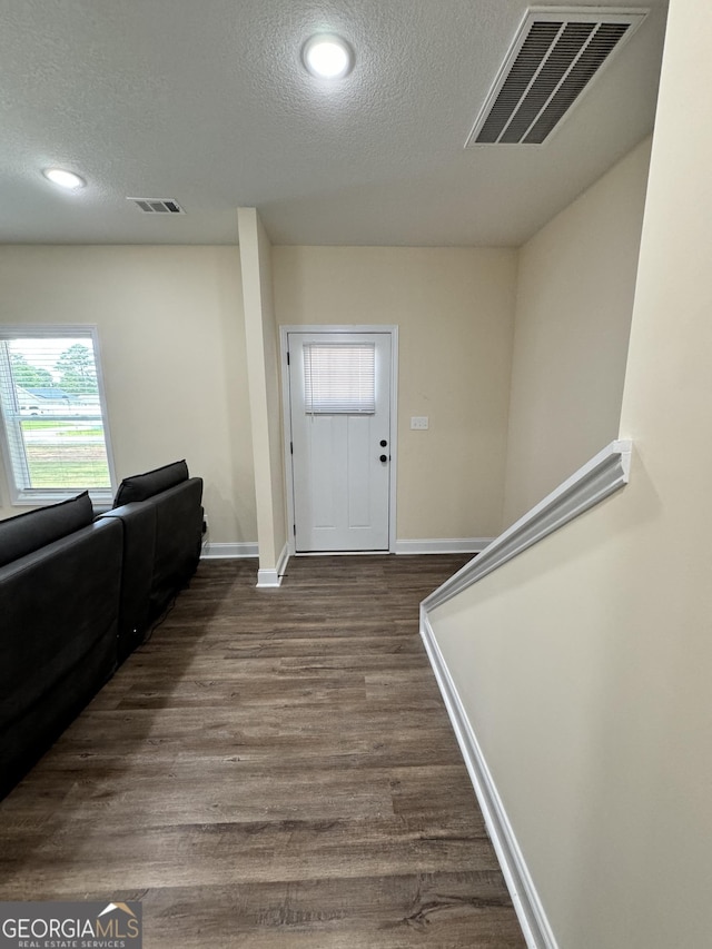 entrance foyer with hardwood / wood-style floors and a textured ceiling