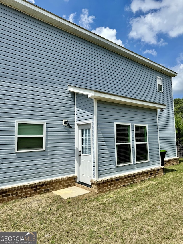 rear view of house featuring a lawn