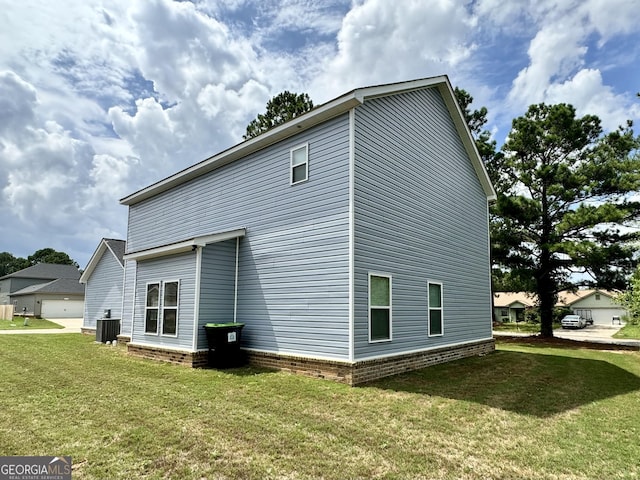 view of side of home with central AC unit and a lawn