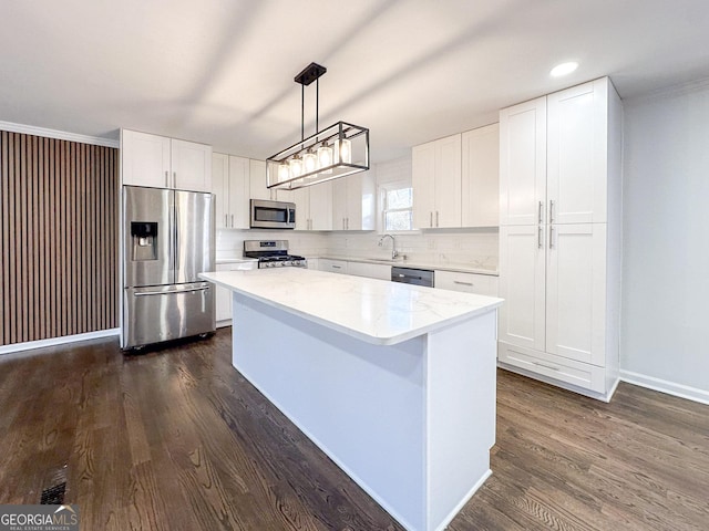 kitchen featuring sink, white cabinetry, stainless steel appliances, a center island, and decorative light fixtures