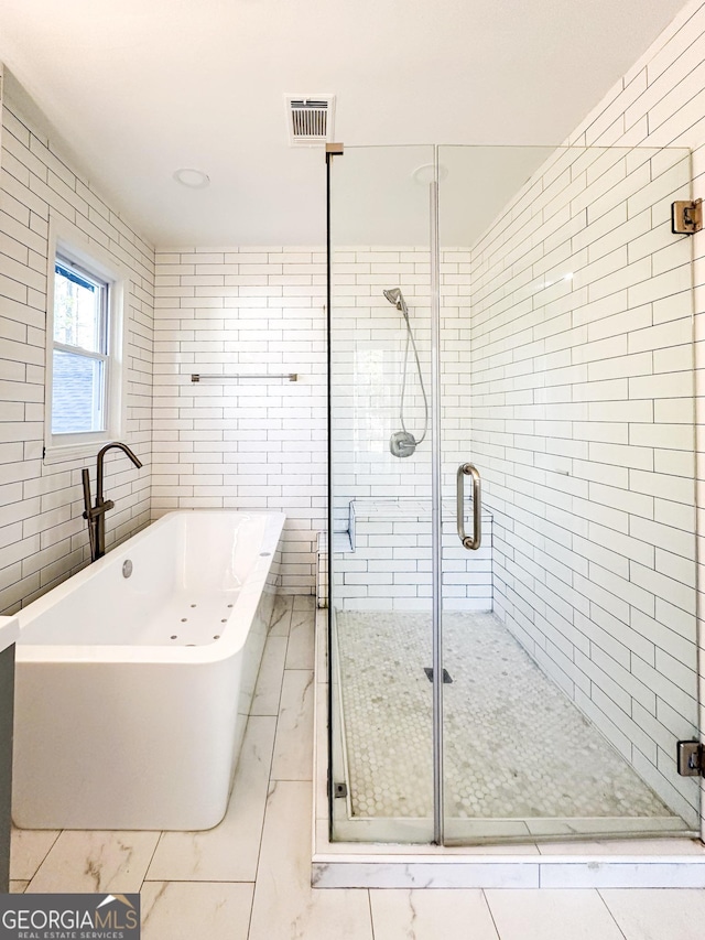 bathroom featuring independent shower and bath and tile walls