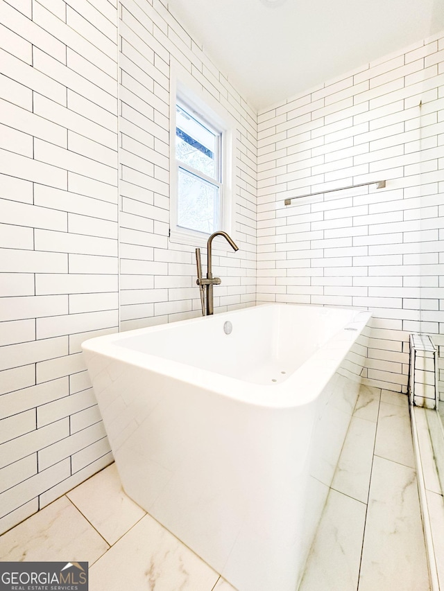 bathroom featuring tile walls and a tub to relax in