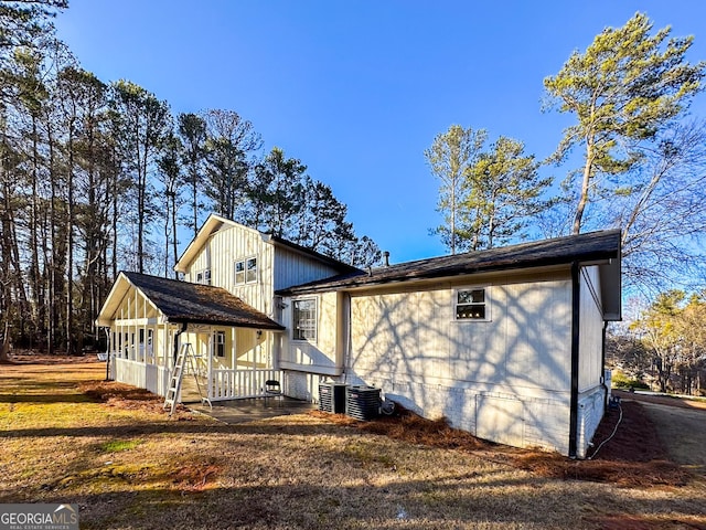 view of side of property with a porch and central AC