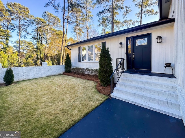 entrance to property featuring a lawn