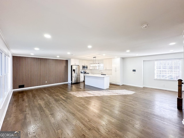 unfurnished living room with crown molding and wood-type flooring