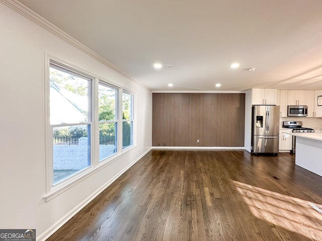 unfurnished living room with dark hardwood / wood-style flooring and ornamental molding