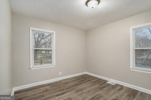 empty room with dark hardwood / wood-style flooring