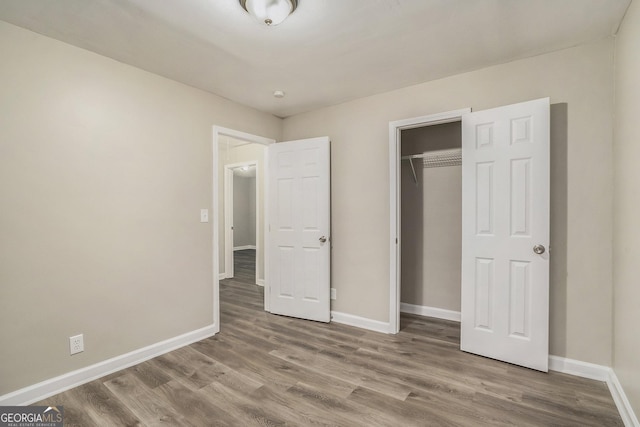 unfurnished bedroom featuring wood-type flooring and a closet