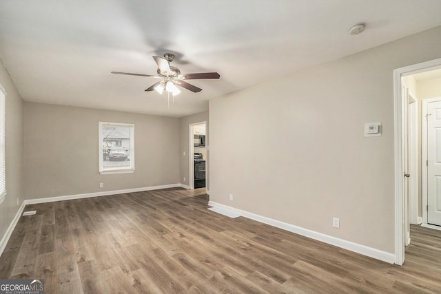 spare room featuring dark wood-type flooring and ceiling fan