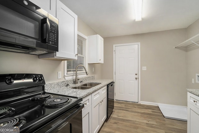 kitchen with light stone countertops, black appliances, and white cabinets