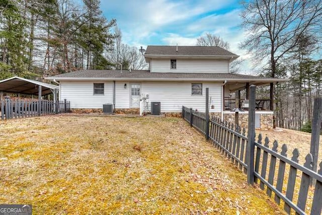 back of house with a carport, a yard, and cooling unit