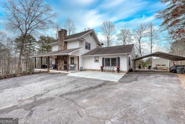 view of front property featuring a porch and a carport