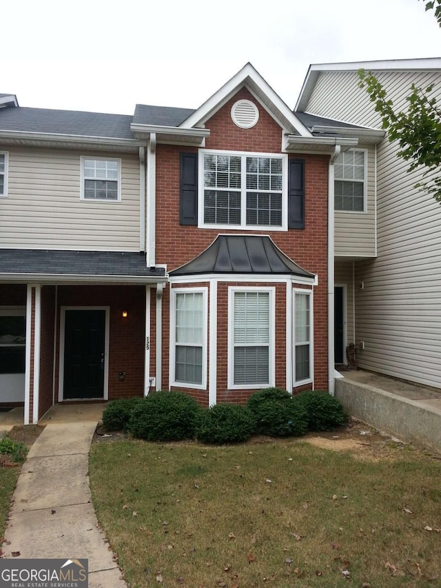 townhome / multi-family property with a front lawn