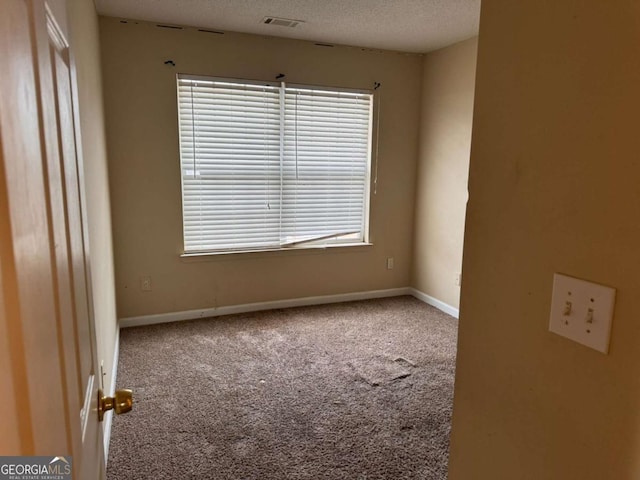 carpeted empty room featuring a textured ceiling