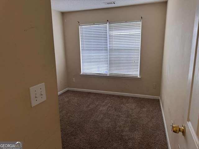 spare room with a textured ceiling and carpet flooring