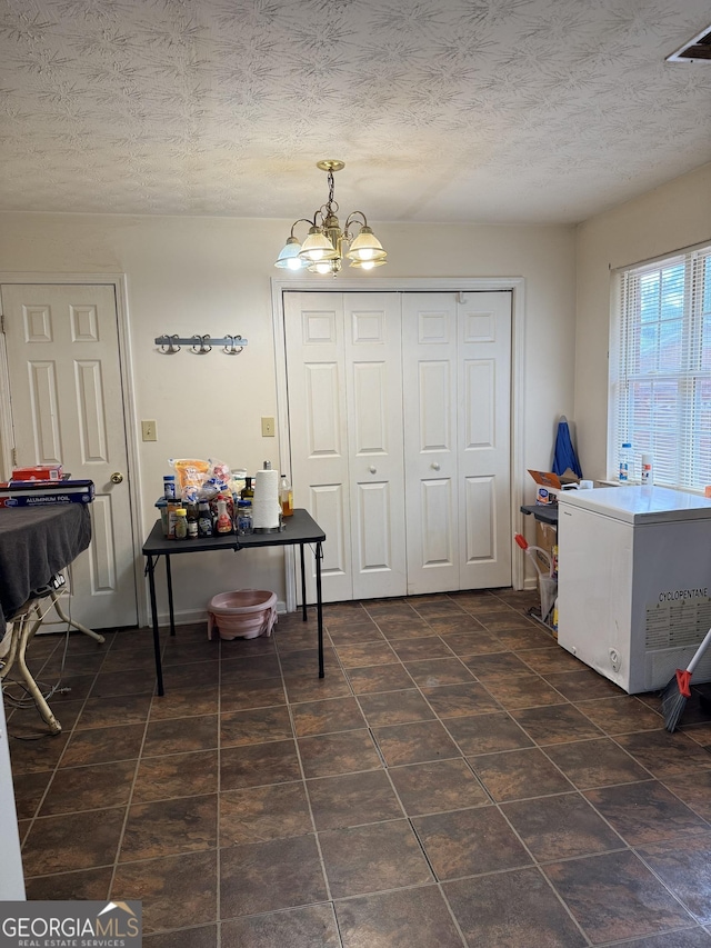 241 E Ash St, Social Circle, GA 30025 - dining area with visible vents, a textured ceiling, a chandelier, and dark tile patterned floors